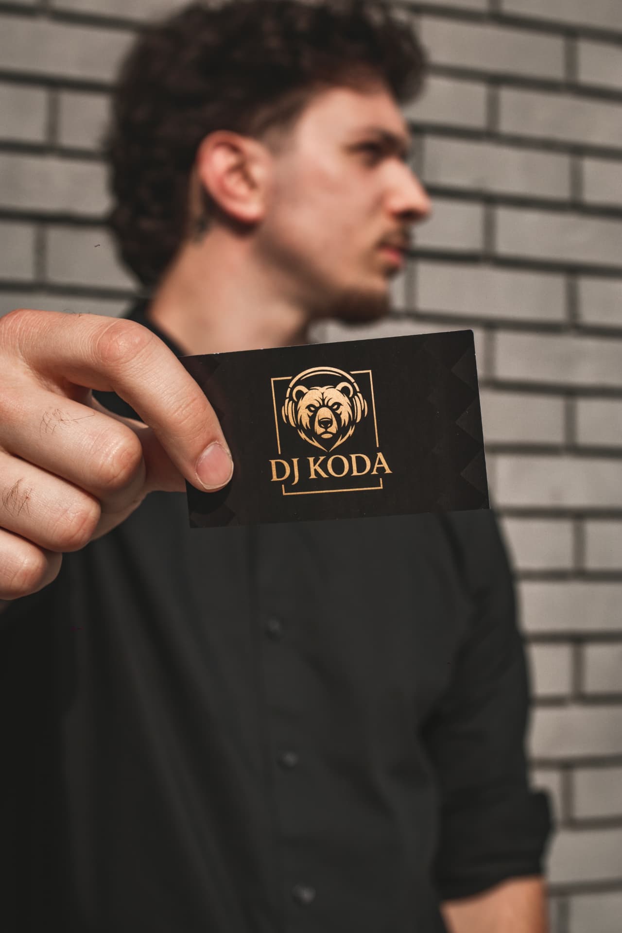 DJ Koda holding a black and gold DJ Koda business card